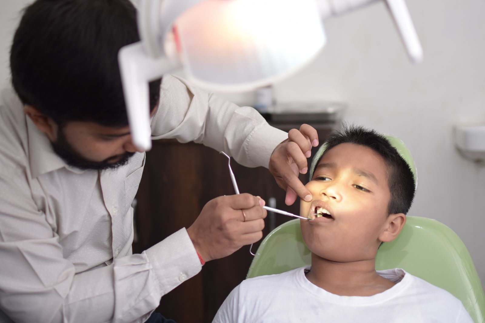 Pedodontist examining a young boy's teeth during a checkup in Christiansburg VA