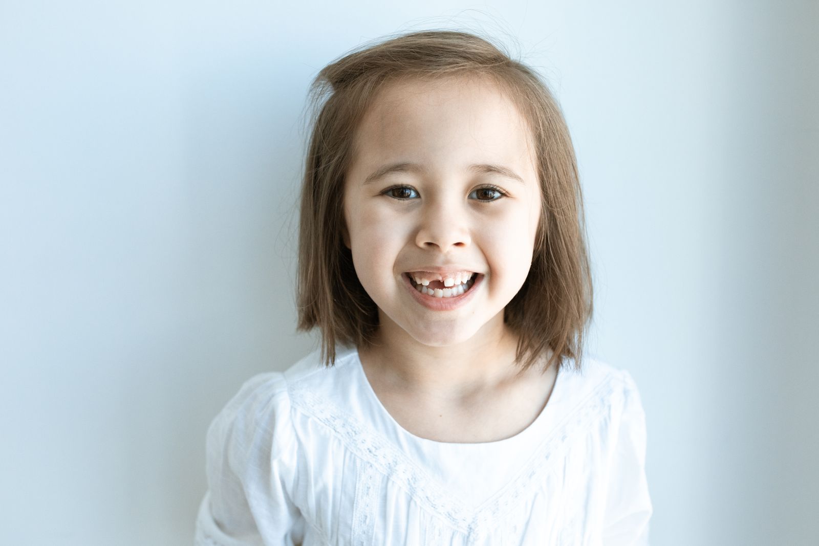 Smiling girl with a missing front baby tooth