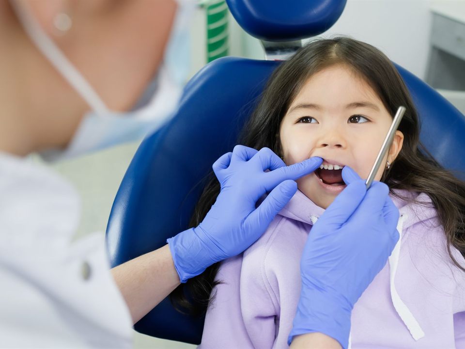 Dentist checking a young girl's teeth before fluoride varnish treatment at our pediatric dentist office in Christiansburg, VA