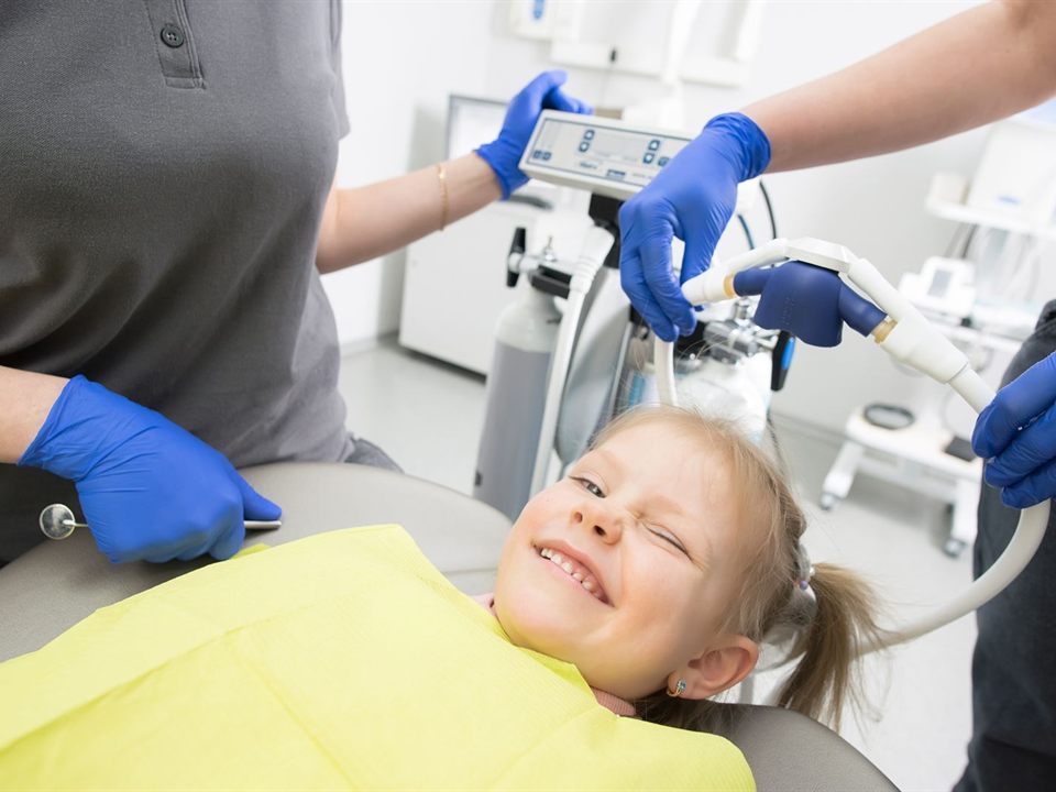 Smiling child in a dental chair as the team places a nitrous oxide nose mask at our pediatric dentist office in Christiansburg, VA