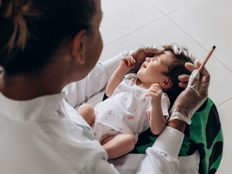 Health care provider gently examining a newborn baby during a tongue-tie evaluation in Christiansburg, VA